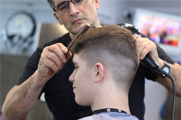 Father cutting reluctant sons hair in bathroom stock photo
