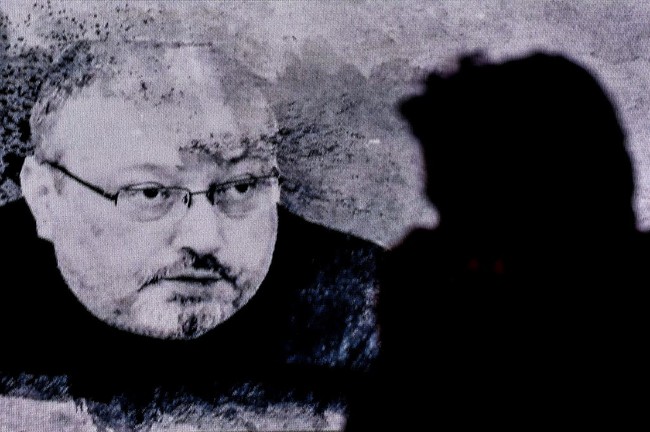 In this file photo taken on November 11, 2018 a man passes in front of a screen showing Jamal Khashoggi during a commemoration event of Khashoggi's supporters in Istanbul. [File Photo: AFP]