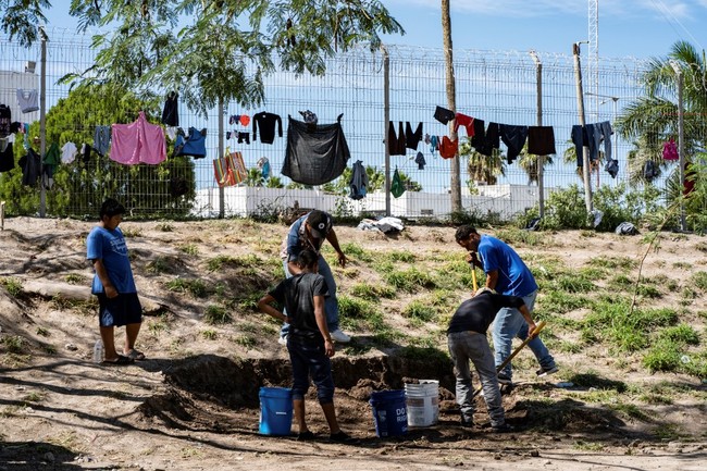 Migrant men are seen digging to create a more secure structure to prevent flooding in the next rainfall, in Matamoros, Tamaulipas state, Mexico, near to the border with the United States, on November 1, 2019. [Photo: AFP]