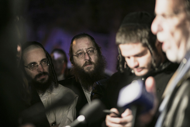 Orthodox Jewish people listen to N.Y. state Assemblyman Dov Hikind speak in Monsey, N.Y., Sunday, Dec. 29, 2019, following a stabbing late Saturday during a Hanukkah celebration. A man attacked the celebration at a rabbi's home north of New York City late Saturday, stabbing and wounding several people before fleeing in a vehicle, police said. [Photo: AP]