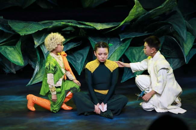 Two amateur actors on stage with a professional performer from the China National Theatre for Children on Sunday, December 29, 2019.[Photo: China Plus]