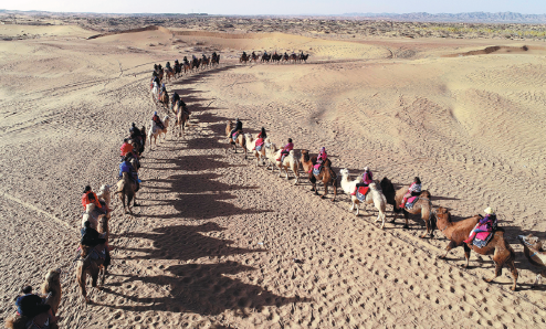 Turisté jezdí na velbloudech v poušti Alshaa v západní autonomní oblasti Vnitřní Mongolsko. Fotografie: tisková agentura Nová Čína / Xinhua