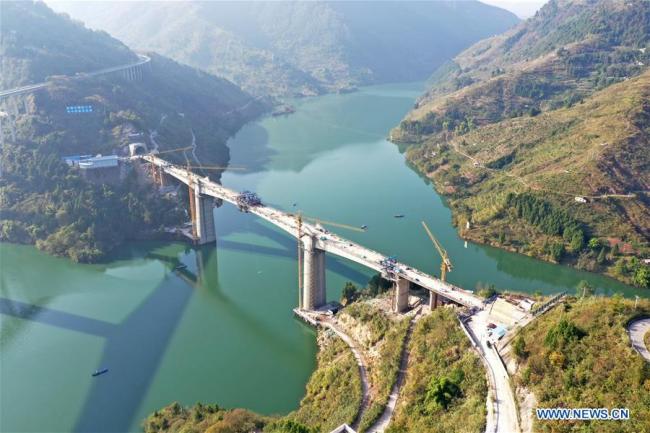 6, Fotografie pořízená 8. listopadu 2020 ukazuje staveniště vysokorychlostního železničního mostu přes řeku Tangxi (Tchang-si) v městečku Yunyang (Jün-jang) na jihozápadě čínského města Chongqing (Čchung-čching). 8. listopadu byla dokončena závěrečná etapa překlenutí tohoto mostu s délkou 472,7 metru, který je součástí vysokorychlostní železnice s délkou 818 kilometrů, která spojuje Zhengzhou (Čeng-čou), hlavní město provincie Henan (Che-nan), s okresem Wanzhou (Wan-čou) v Chongqingu. (Xinhua / Tang Yi)