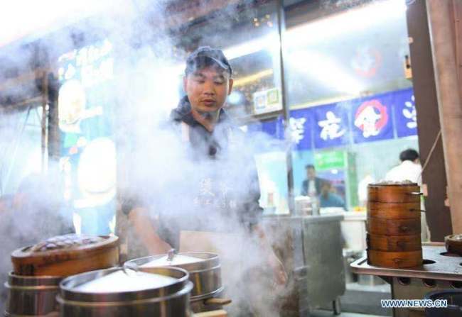 3, Zaměstnanec pracuje 10. listopadu roku 2020 v restauraci na nočním trhu v městečku Shouchang (Šou-čchang) pod správou města Jiande (Ťien-te) ve východočínské provincii Zhejiang (Če-ťiang). Shouchang, malé městečko v hornaté oblasti provincie Zhejiang, zřídilo speciální noční trh, který spojuje noční stánky a více než 30 restaurací, aby obohatily volný čas lidí a podpořily místní ekonomiku. Noční trh přijal více než 720.000 turistických výletů a od otevření během Svátku práce vydělal 76,33 milionu yuanů (asi 11,57 milionu amerických dolarů). (Xinhua / Weng Xinyang)