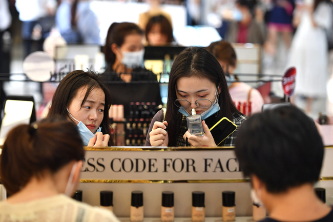 Nakupující si vybírá kosmetiku v bezcelním obchodě v Haikou (Chaj-kou) v provincii Hainan (Chaj-nan). Fotografie: tisková agentura Nová Čína / Xinhua