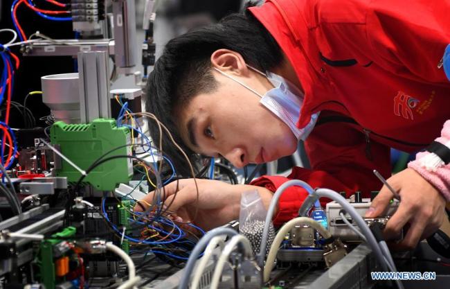 Soutěžící se účastní výrobní a inženýrské akce v druhý den první soutěže odborných dovedností Čínské lidové republiky, která se konala 11. prosince 2020 v Kantonu v jihočínské provincii Guangdong (Kuang-tung). (Xinhua / Lu Hanxin)
