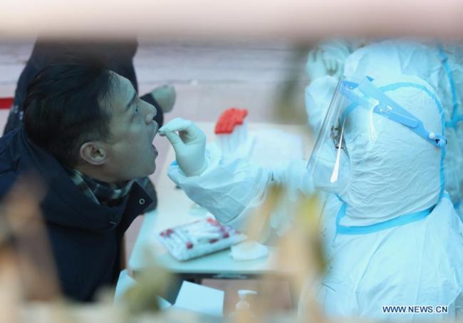 Zdravotnický pracovník odebírá vzorky výtěrů od obyvatelů na sídlišti ve čtvrti Qiaoxi v Shijiazhuang, hlavním městě severočínské provincie Hebei, 6. ledna 2021. Shijiazhuang začal ve středu provádět v celém městě testy nukleových kyselin. (Xinhua)