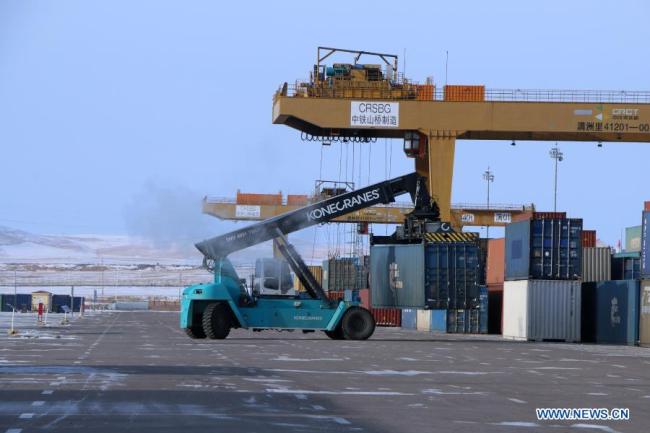 Fotografie pořízená 5. ledna 2021 ukazuje portálový jeřáb nesoucí kontejner v Manzhouli v severočínské autonomní oblasti Vnitřní Mongolsko. Počet čínsko-evropských nákladních vlaků, které přijíždějí a odjíždějí přes Manzhouli, největší čínský pozemní přístav, dosáhl v roce 2020 rekordu i přes dopad COVID-19, uvedly ve středu místní železniční úřady. (Foto: Guo Nailun / Xinhua)