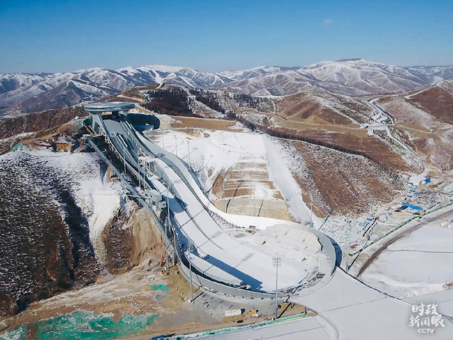 Národní středisko pro skoky na lyžích je vybudováno v údolí a jeho hlavní design je inspirován tradičním čínským ornamentem „Ruyi“ (Žu-i), proto se nazývá „Sněžné Ruyi“. (CMG / Li Yang, Liu Chong)