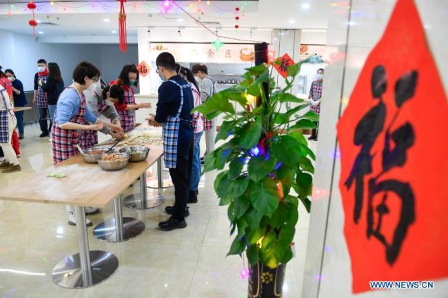 Zdravotničtí pracovníci dělají taštičky v místě svého umístění ve městě Tonghua (Tchung-chua) v provincii Jilin (Ťi-lin) na severovýchodě Číny, 11. února 2021. Letošní Jarní svátek připadá na pátek. (Xinhua / Xu Chang)
