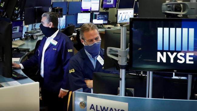 Obchodníci v maskách pracují na místě na newyorské burze cenných papírů (NYSE) v New Yorku, USA, 26. května 2020. / Reuters