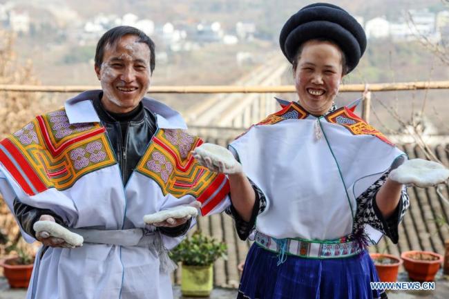 Vesničan Ma Yong (Ma Jung, vlevo) a jeho manželka Huang Guoqin (Chuang Kuo-čchin), z etnické skupiny Miao, vystavují lepkavé rýžové svačiny Ciba (Cch'-pa), které vyrobili před lunárním Novým rokem v okrese Nayong (Na-jung) ve městě Bijie (Pi-ťie) v provincii Guizhou (Kuej-čou) na jihozápadě Číny, 10. února 2021. Lunární Nový rok patří k nejvýznamnějším svátkům v Číně a oslavné činnosti jsou rozmanité, včetně jídla. Když přichází lunární Nový rok, lidé po celé Číně připravují různá občerstvení, která, jak věří, jim přinesou štěstí. (Xinhua / Ou Dongqu)