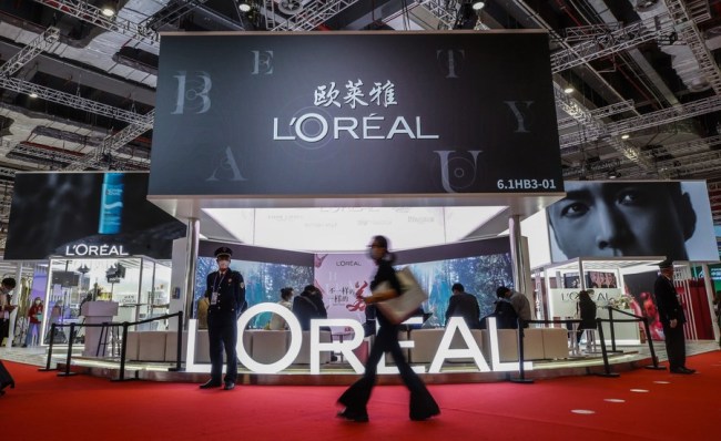 Návštěvník prochází kolem stánku společnosti L'Oreal na výstavní ploše pro spotřební zboží během třetího Čínského mezinárodního dovozního veletrhu (CIIE) v Šanghaji ve východní Číně 7. listopadu 2020. (Xinhua / Zhang Yuwei)
