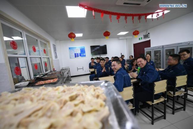 Pracovníci se scházejí, aby oslavili Jarní svátky na konvertorové stanici ±800 kV společnosti State Grid na pastvinách Xilingol v severočínské autonomní oblasti Vnitřní Mongolsko, 11. února 2021. Všech 59 pracovníků konvertorové stanice se rozhodlo zůstat ve firmě během oslav letošních Jarních svátků. V předvečer čínského lunárního Nového roku asi 20 zaměstnanců pracovalo na svých pozicích, zatímco ti, kteří měli přestávku, vařili taštičky a vyzdobili konvertorovou stanici papírovými vystřihovánkami. (Xinhua / Liu Lei)