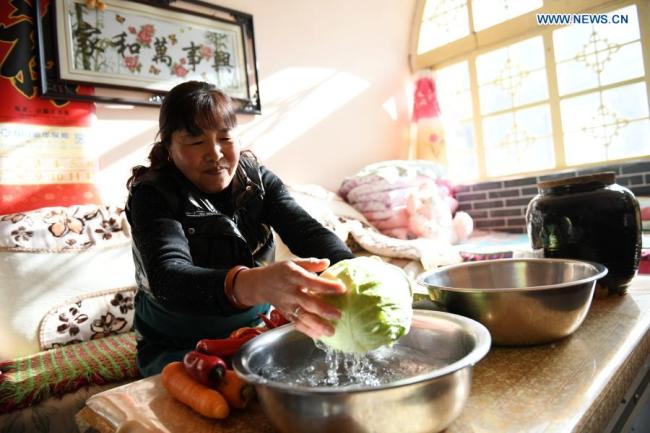 Vesničanka Dong Lirong (Tung Li-žung) dělá doma nakládanou zeleninu ve vesnici Liangjiahe (Liang-ťia-che) v provincii Shaanxi (Šen-si) v severozápadní Číně, 6. ledna 2021. (Xinhua/Li Yibo)