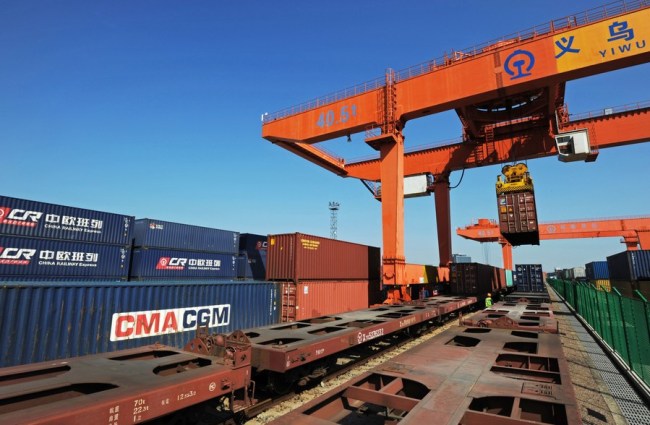 Portálový jeřáb nakládá kontejner na čínsko-evropský nákladní vlak v čínském Yiwu 27. října 2018. (Xinhua / Tan Jin)