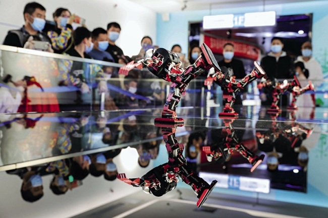 Diváci sledují taneční představení skupiny robotů ve vědeckém a technologickém muzeu v Baofeng v provincii Henan, 14. února 2021.