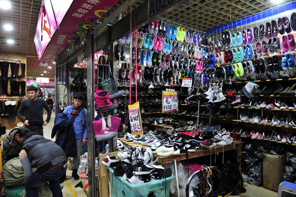 Un puesto ofrece zapatos con descuento debido al traslado del mercado. Fotos de Dong Ning