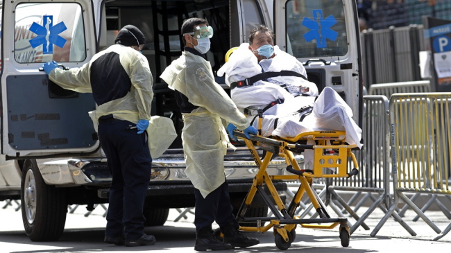 Un paciente sale en camilla desde el Centro Hospitalario Elmhurst hasta una ambulancia que lo espera en Nueva York, EE. UU., 7 de abril de 2020 /AP