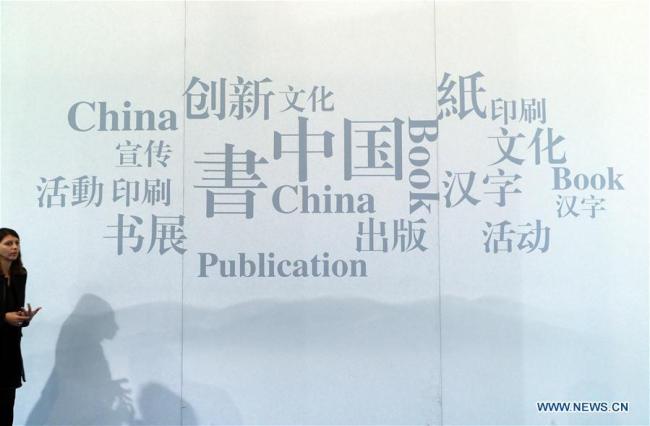 Une femme passe devant un panneau du pavillon chinois de la 69e Foire du livre de Francfort, en Allemagne, le 11 octobre 2017.