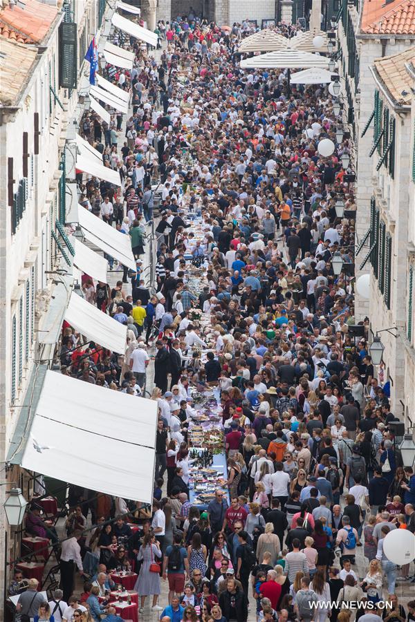 Des personnes attendent de déguster des plats lors du Festival des bons aliments, à Dubrovnik, en Croatie, le 22 octobre 2017. La clôture de ce festival de quatre jours a été marquée dimanche par la "Table de Dubrovnik", s'étendant le long de la Rue de Stradun, dans la vieille ville. (Photo : Grgo Jelavic)