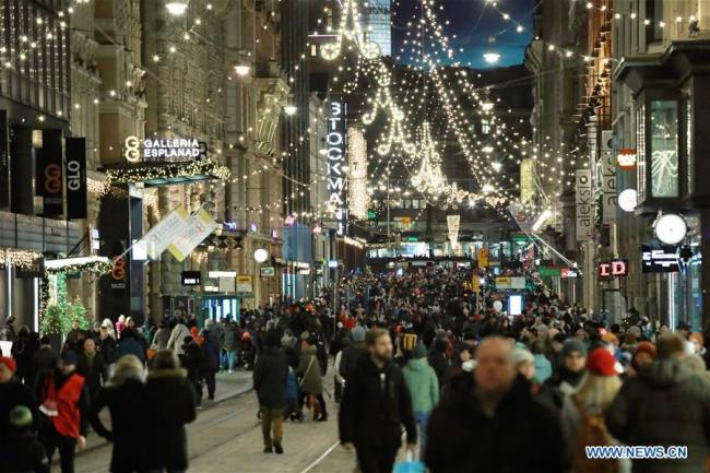 La foule dans une rue illuminée à Helsinki en Finlande, le 26 novembre 2017. Une cérémonie traditionnelle a été organisée dimanche dans le centre-ville d'Helsinki pour fêter le début de la saison de Noël. (Photo : Li Jizhi)