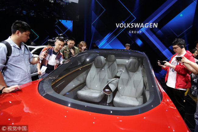 Des journalistes visitent un concept-car Volkswagen I.D. lors d'un événement médiatique organisé avant le salon Auto China 2018, le 24 avril 2018 à Beijing.