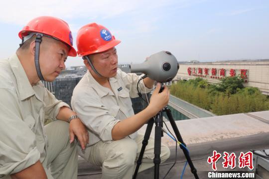 Deux ingénieurs se servent d'un appareil de réalité virtuelle sur une zone de démonstration pour la mise en place d'un réseau de télécommunication 5G ultra-rapide dans le quartier d'affaires de Hongqiao, à Shanghai, le 17 mai 2018. [Crédit photo : China News Service]
