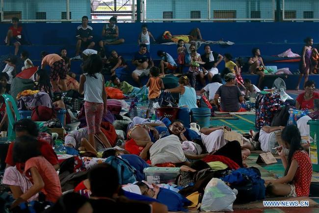  Des habitants se réfugient temporairement dans un terrain de basket couvert à cause des inondations apportées par la tempête tropicale Son-Tinh à Quezon City aux Philippines, le 18 juillet 2018. (Photo : Rouelle Umali)