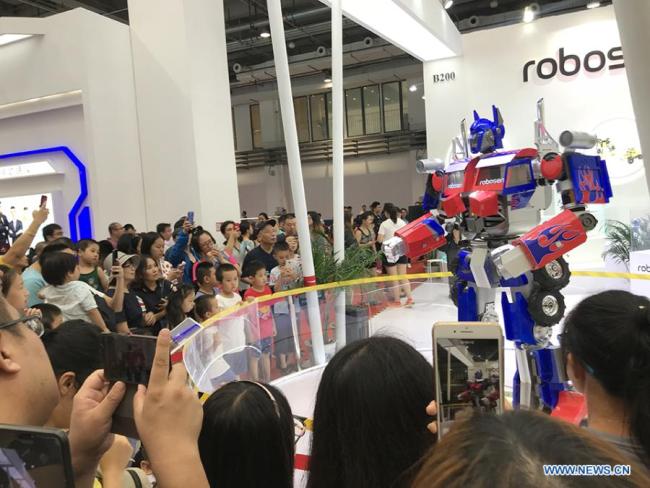 Des visiteurs regardent un robot lors de la World Robot Conference 2018 (Conférence mondiale des robots) à Beijing, le 17 août 2018. Cette conférence a attiré un total de 166 entreprises nationales et internationales présentant leurs technologies de pointe, et plus de 500 robots différents ont fait des démonstrations sur scène. 