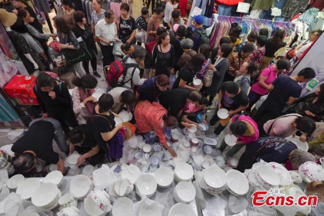 Des clients achètent des biens lors d'une vente de liquidation au marché de gros de Guanyuan, situé dans le district de Xicheng de Beijing, le 28 septembre 2018.