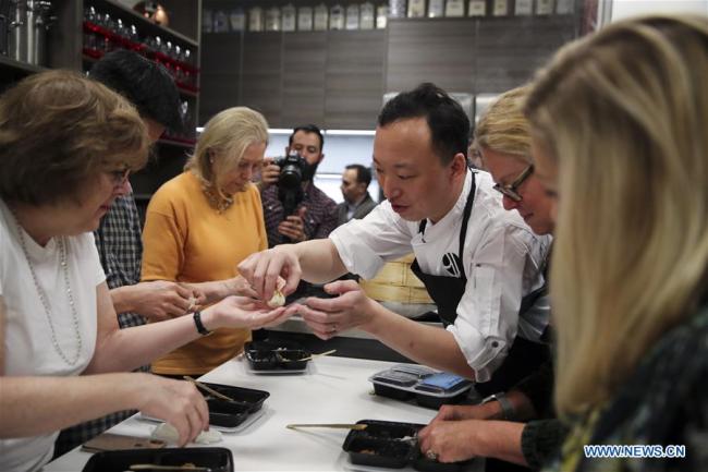 Des gens apprennent à préparer des xiaolongbao, une sorte de ravioli chinois, lors du Festival de la gastronomie et de la promotion du tourisme de Shanghai, à New York, aux Etats-Unis, le 19 novembre 2018. (Photo : Wang Ying)