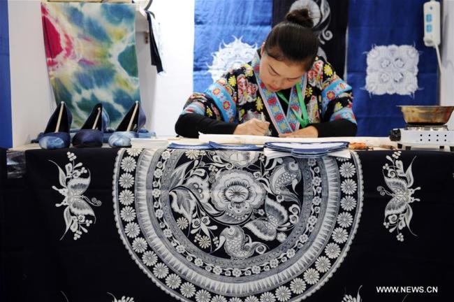 Une participante fabrique des articles batik lors du Salon international de l'artisanat folklorique et des produits culturels de Chine (Guizhou) 2018, à Guiyang, dans la province chinoise du Guizhou (sud-ouest), le 23 novembre 2018. Plus de 200 artisans ont présenté leurs compétences et leurs produits traditionnels à l'occasion du salon du patrimoine culturel intangible qui s'est ouvert vendredi à Guiyang. (Photo : Yang Wenbin)