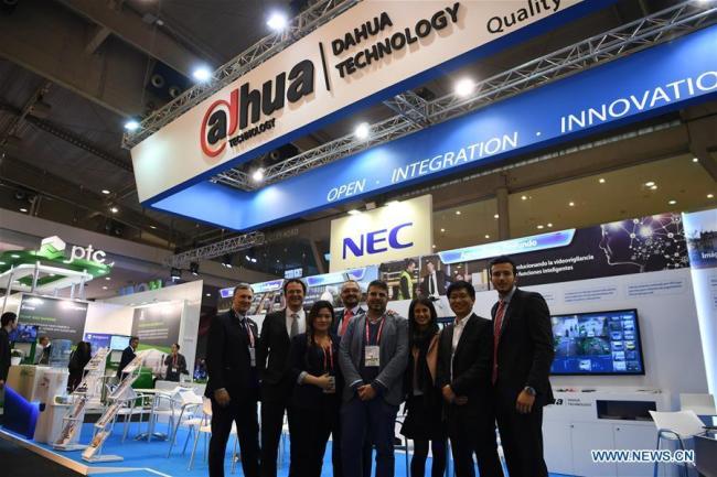 Des membres du personnel de Zhejiang Dahua Technology Co. Ltd. posent pour une photo de groupe lors du congrès mondial de l'Exposition des villes intelligentes (Smart City Expo World Congress) à Barcelone, en Espagne, le 15 novembre 2017.