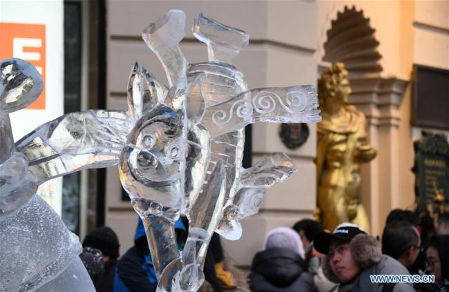 Des touristes regardent une sculpture de glace sur la rue centrale de Harbin. Les sculptures de glace sont devenues une attraction très appréciée des touristes pendant les congés du Nouvel An.