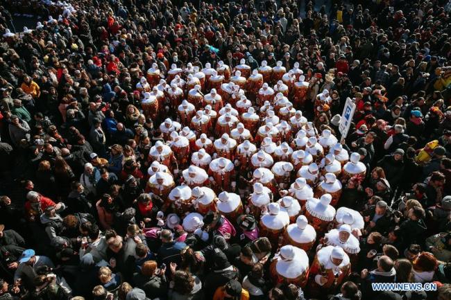 Des habitants portant des costumes de Gilles lancent des oranges qui symbolisent la bonne chance lors du défilé du Mardi Gras, le dernier jour du Carnaval de Binche, en Belgique, le 5 mars 2019. Le Carnaval de Binche de trois jours, l'un des carnavals les plus fameux en Europe, a atteint mardi son apogée. (Xinhua/Zhang Cheng)