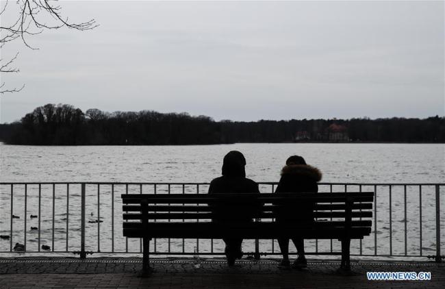 Deux personnes s'assoient sur un banc au bord du lac de Tegel à Berlin, capitale de l'Allemagne, le 12 mars 2019. (Xinhua/Shan Yuqi)
