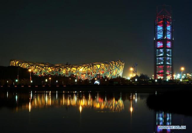 Photo prise le 14 mai 2019 montrant une vue nocturne du Stade national, également appelé le Nid d'Oiseau, et de la tour Linglong à Beijing.