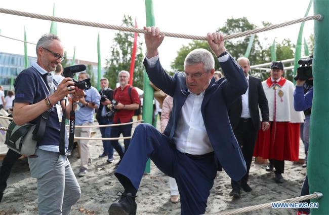 Le président du Comité international olympique (CIO), Thomas Bach (devant à droite), teste un équipement lors de l'inauguration d'un terrain de jeu à Lausanne, en Suisse, le 22 juin 2019.<br><br>