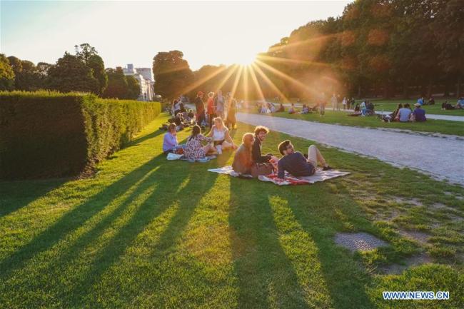 Des gens se reposent sur la pelouse dans le parc du Cinquantenaire à Bruxelles, en Belgique, le 21 juin 2019. (Xinhua/Zhang Cheng)