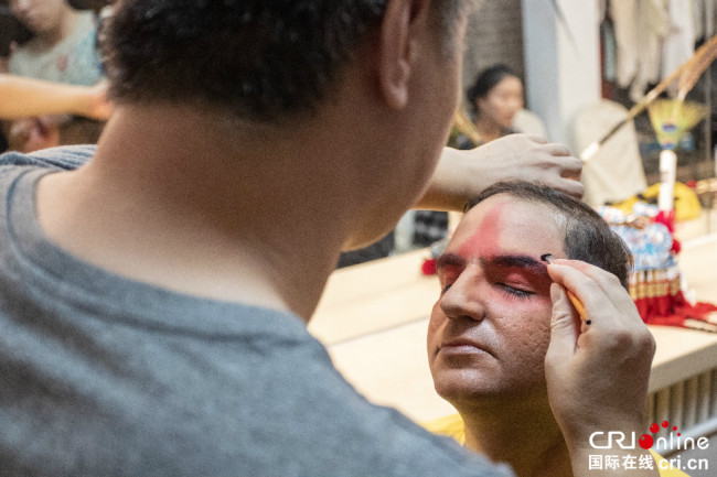 Farvartish Rezvaniyeh, écrivain, pigiste et activiste social iranien, expérimente le maquillage de l’opéra de Beijing