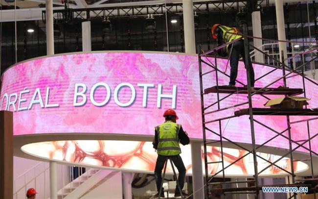 Des employés ajustent un écran LED au Centre national des expositions et des congrès de Shanghai, site de la deuxième édition de l'Exposition internationale d'importation de la Chine (CIIE), à Shanghai, dans l'est de la Chine, le 30 octobre 2019. (Photo : Fang Zhe)