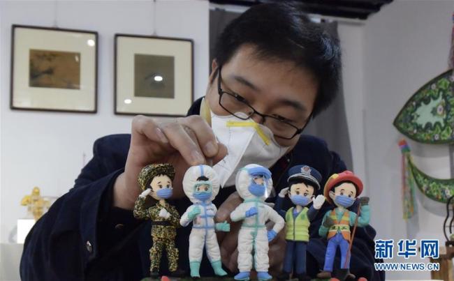 Zhang Yajie présente ses dernières œuvres en pâte représentant du personnel médical dans son atelier à Tianjin, le 11 février 2020. Plusieurs artisans de sculpture en pâte ont créé une série d’œuvres pour exprimer leur solidarité aux professionnels de santé qui se trouvent sur la ligne de front contre l'épidémie. (Photos: Zhou Runjian/Xinhua)