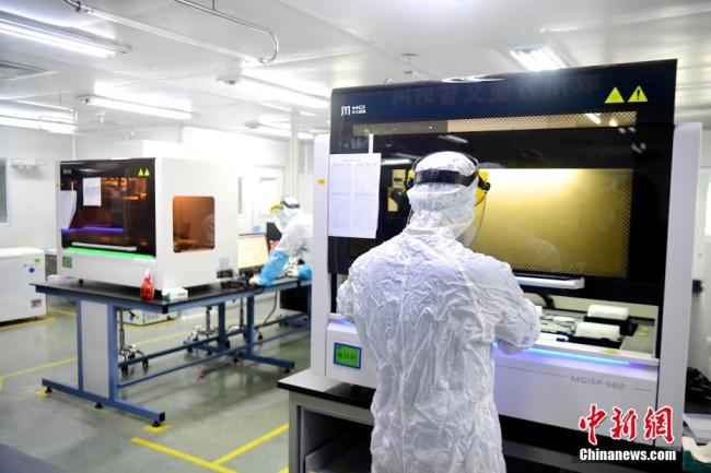 Le 3 mars, des employés travaillent dans un laboratoire du Beijing Genomics Institutesitué à Shenzhen. (Photo: Chen Wen/ChinaNews)