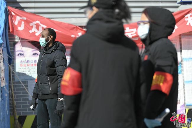 Un jeune Africain sert en tant que bénévole dans un quartier à Beijing pour lutter contre l’épidémie