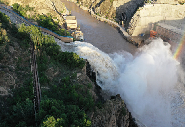 Photo aérienne prise le 26 juin 2020 montrant de l'eau jaillissant d'une écluse du réservoir de Liujiaxia sur le fleuve Jaune, dans la préfecture autonome Hui de Linxia, dans la province du Gansu (nord-ouest de la Chine).