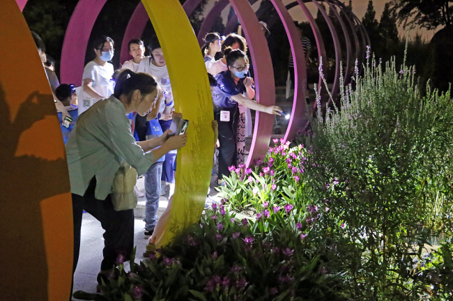Les visiteurs participent à une visite nocturne organisée pour promouvoir les connaissances botaniques au Jardin botanique Chenshan de Shanghai, à Shanghai, dans l'est de la Chine, le 7 août 2020.