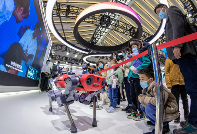 Des visiteurs admirent la démonstration d’un robot quadripode