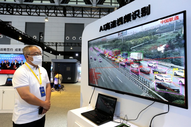 Un employé en train de présenter un système d’intelligence artificielle capable d’analyser les statistiques du trafic autoroutier, le 16 juin, au Salon de l’économie numérique de l’Ouest, à Xi’an.<br>