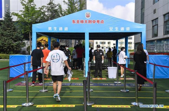 Οι εξεταζόμενοι μπαίνουν στον χώρο των εξετάσεων σε ένα λύκειο στο Τσανγκτσούν, πρωτεύουσα της επαρχίας Τζιλίν της ΒΑ Κίνας, στις 7 Ιουλίου 2020. Η εθνική εξέταση εισόδου πανεπιστημίου του 2020 ξεκίνησαν την Τρίτη.(Xinhua / Xu Chang)<br>